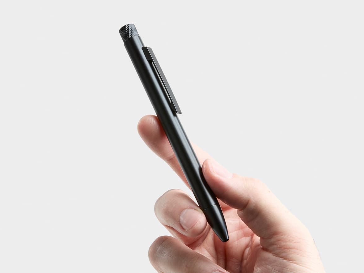 A black pen held by a hand, with "CHINA" visible on its clip.