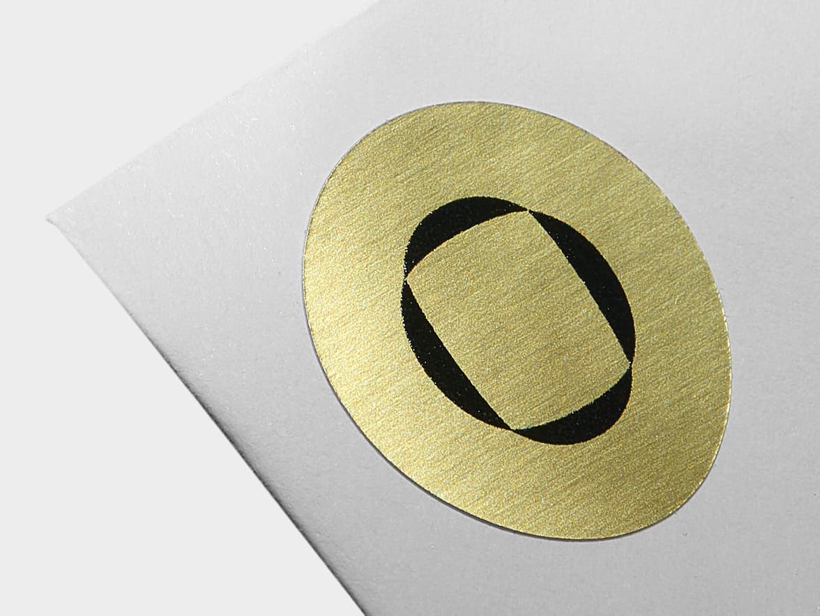 A close up image of a round gold metallic sticker with customization.