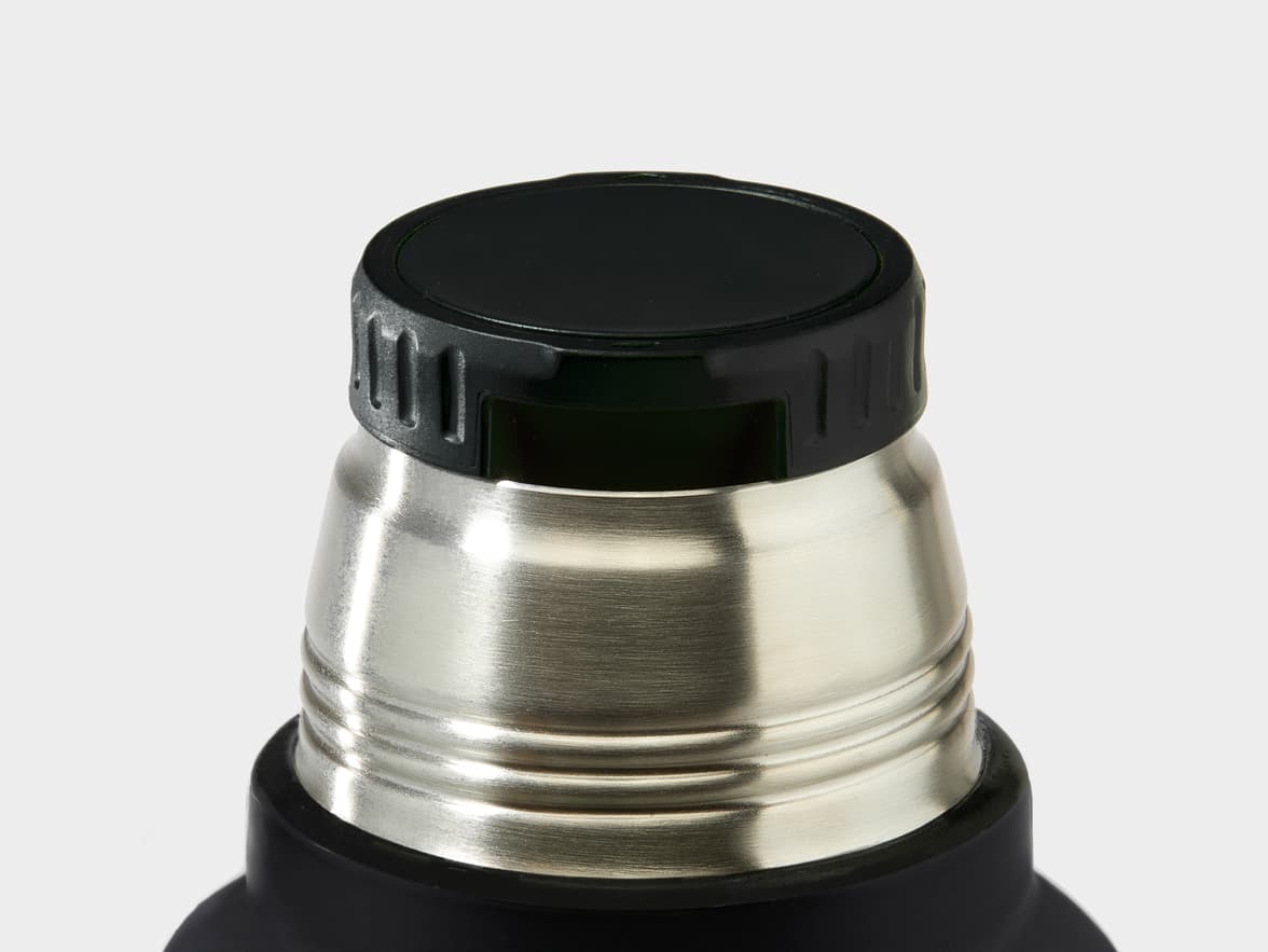 Top of a black thermos with a black screw-on cap and a brushed stainless steel neck.