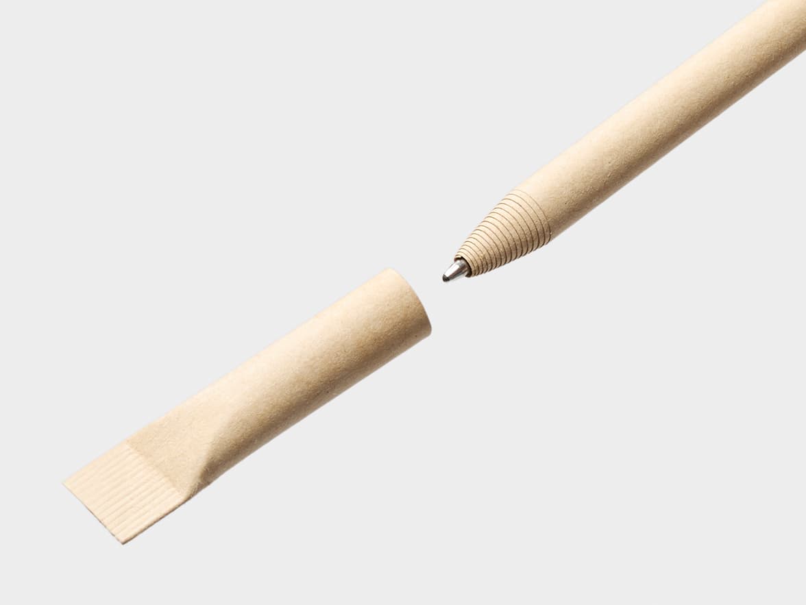 An eco-friendly beige paper pen, disassembled, with the pen tip showing spiraled ridges and the cap separated from the body.