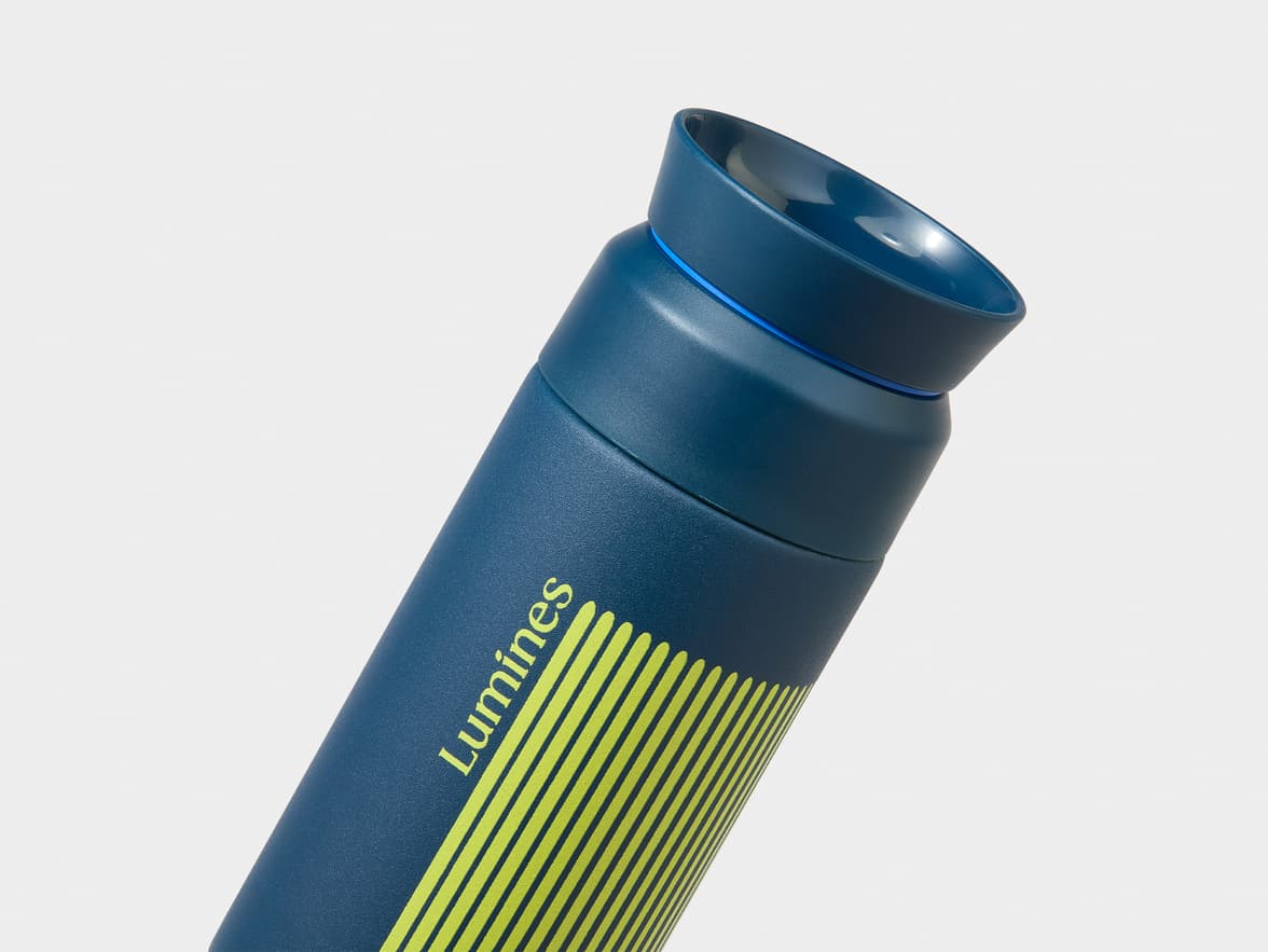 A blue water bottle with the brand "Lumines" in yellow text and yellow stripes, angled on a white background.