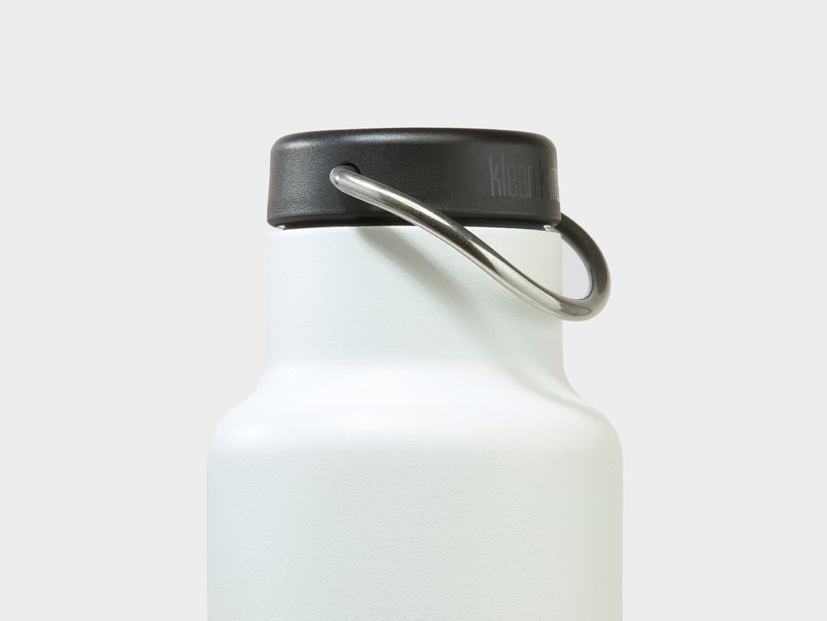 A white Klean Kanteen bottle with a black cap and a metal loop handle.