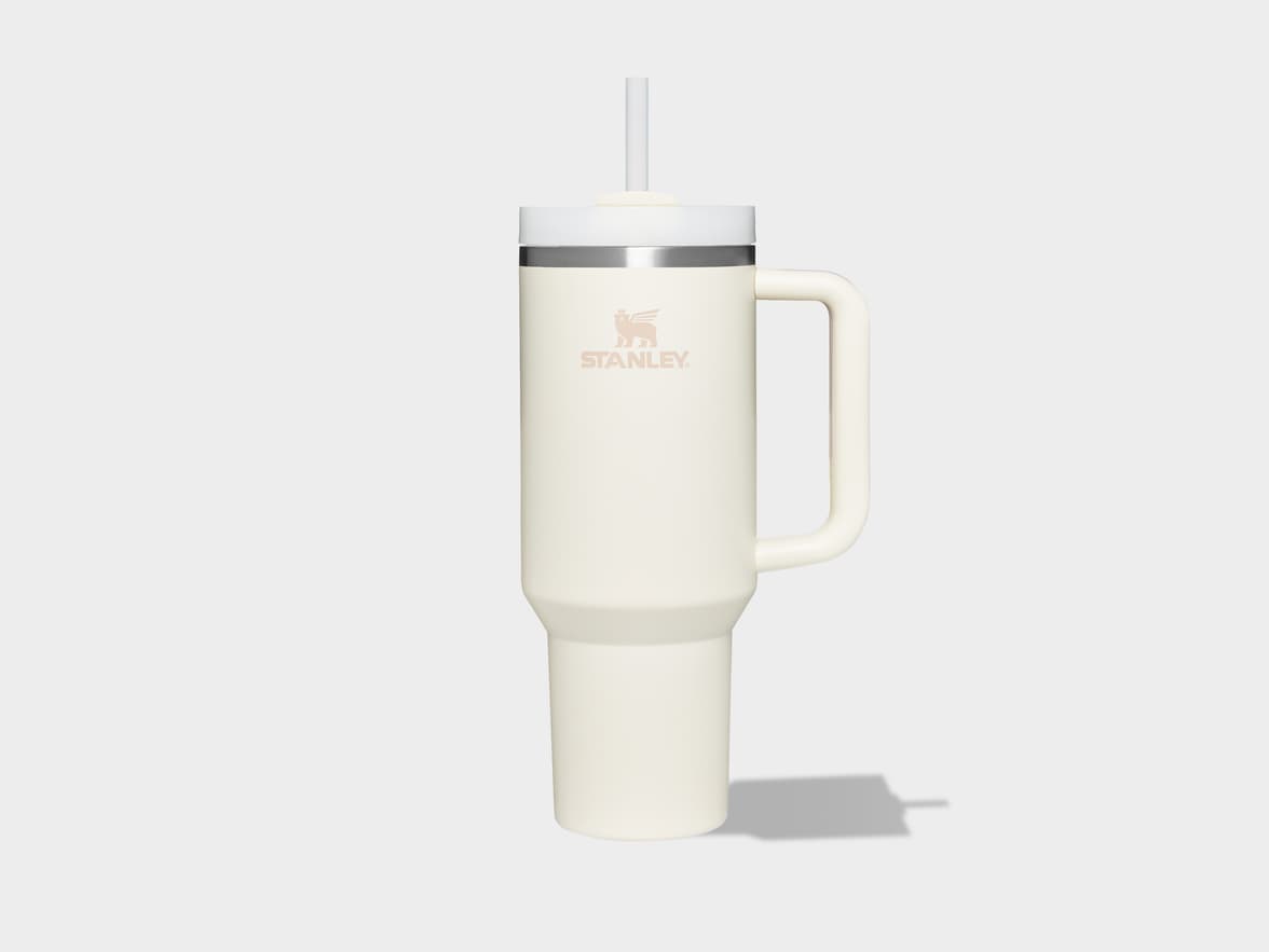 A cream Stanley tumbler with a handle and straw.