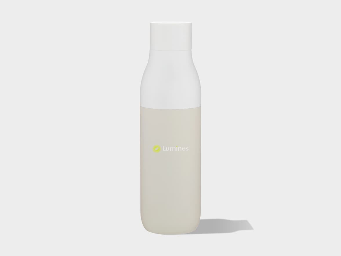 A minimalist product shot of a two-toned bottle, white on top and light beige on the bottom, featuring a yellow-green sunburst logo and the word "Lumines" in white text on the beige section. The bottle stands upright on a light grey background with a subtle shadow.