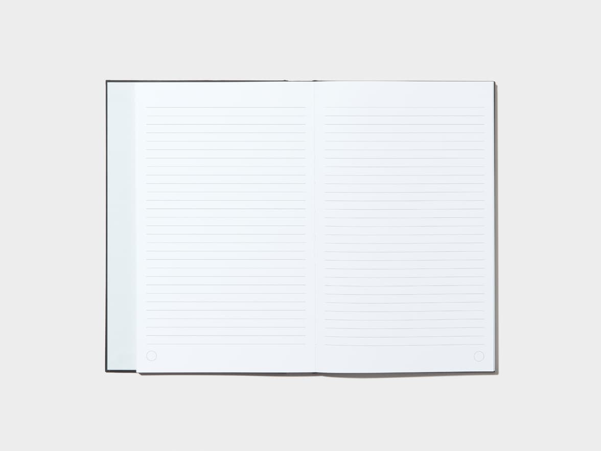 An opened Jet Black Hardcover Notebook with lined pages 