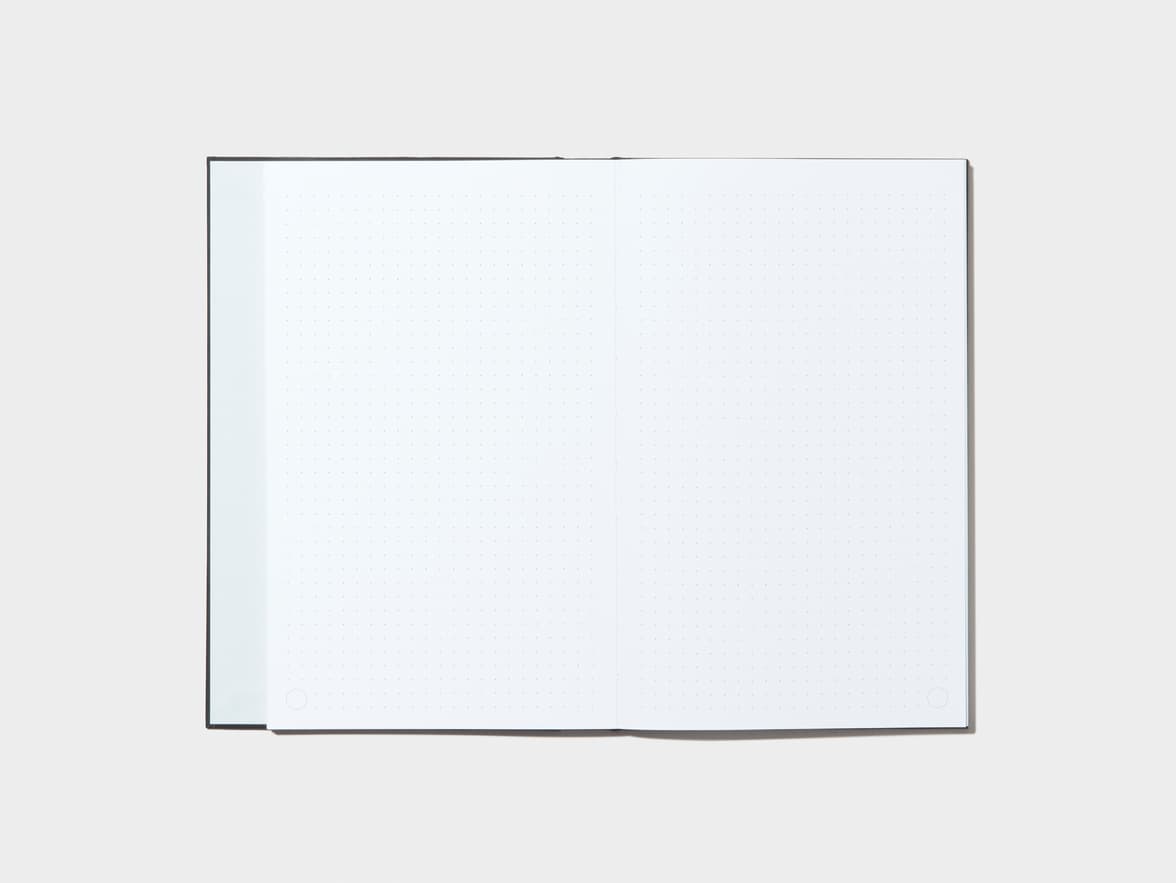 An opened Jet Black Hardcover Notebook with dotted pages 