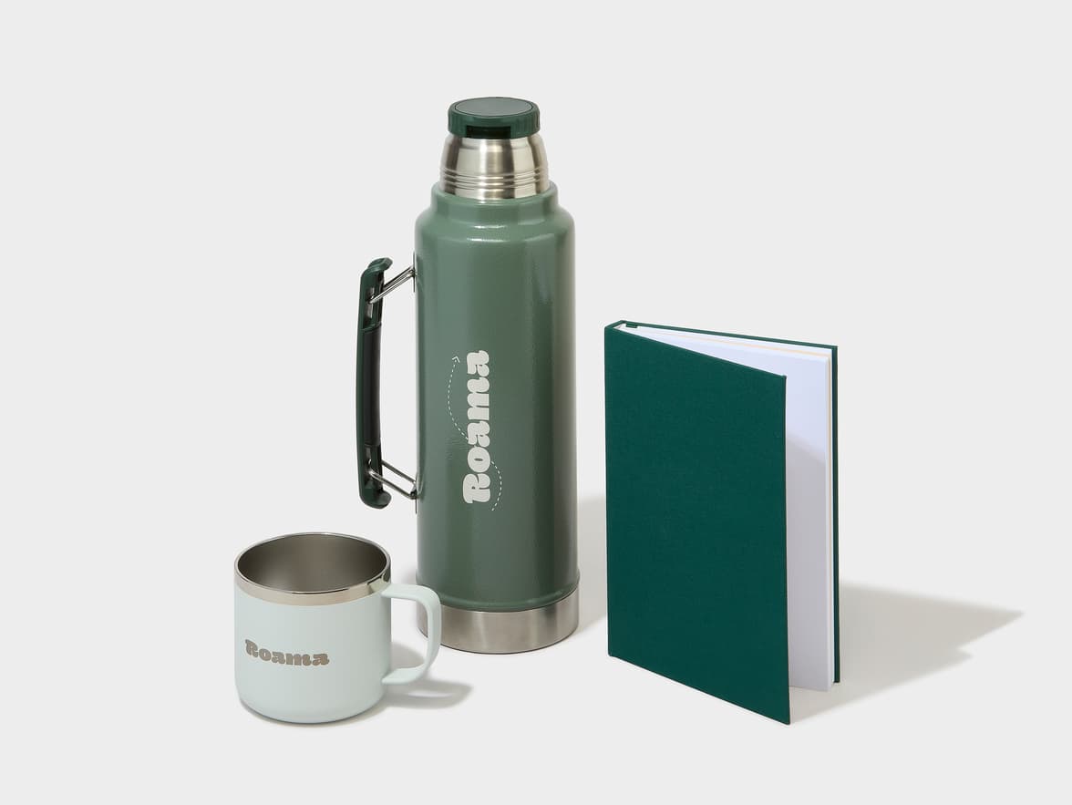 Green Roama thermos, a light green Roama mug, and a dark green notebook.