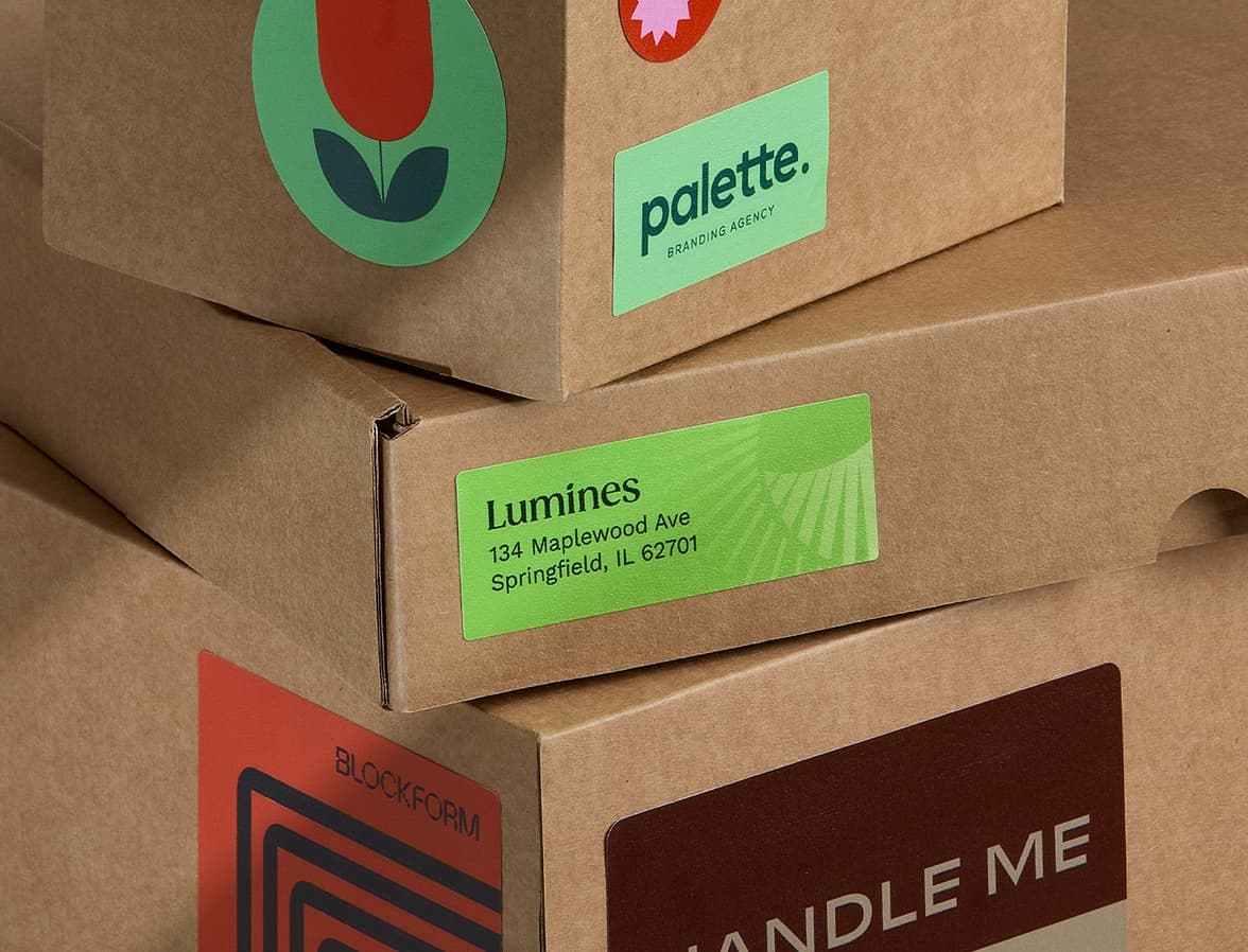 Customized matte paper stickers on three different cardboard boxes.