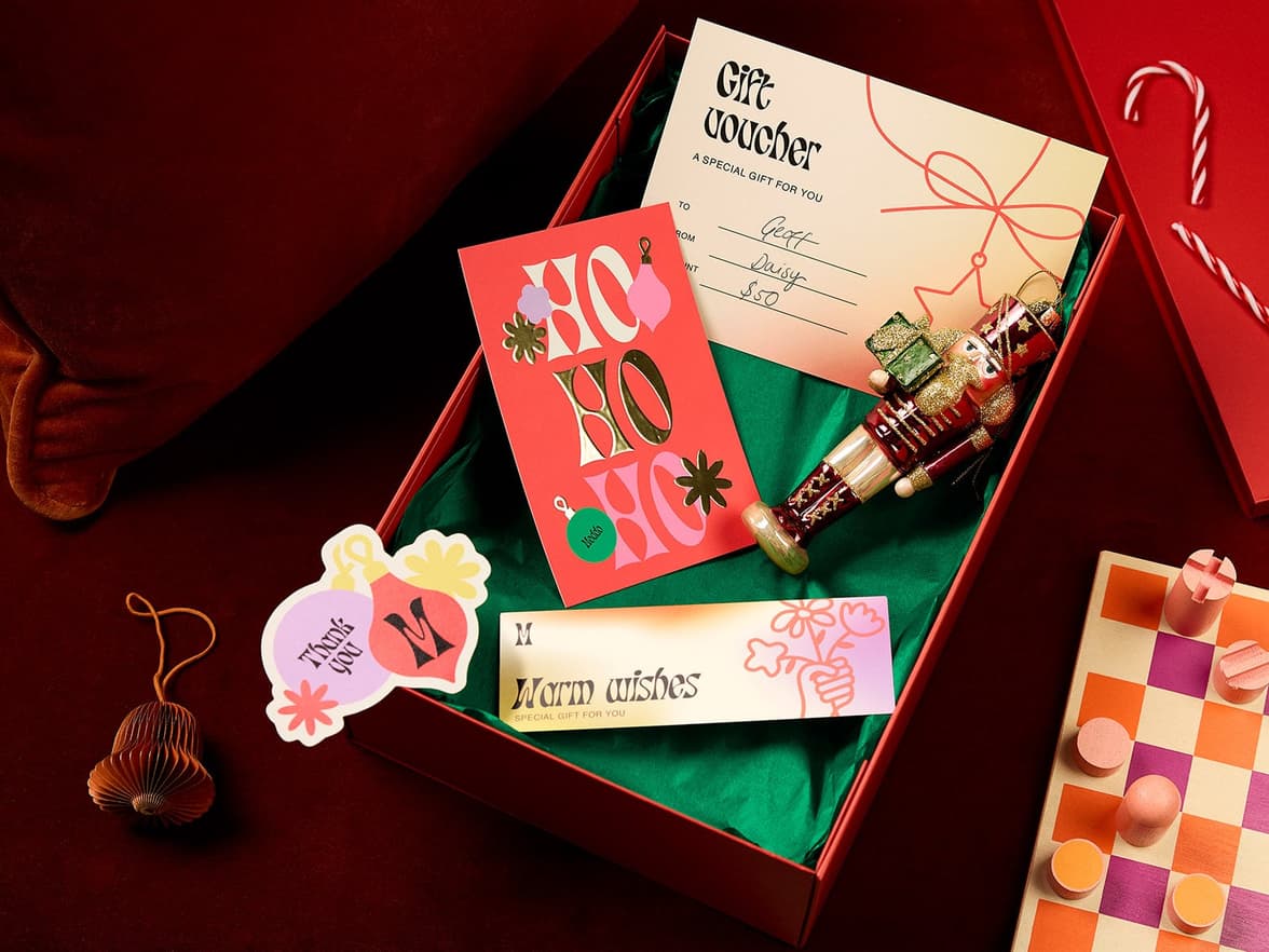 a gift box displayed with a nutcracker, gold foil postcard, sticker & bookmark