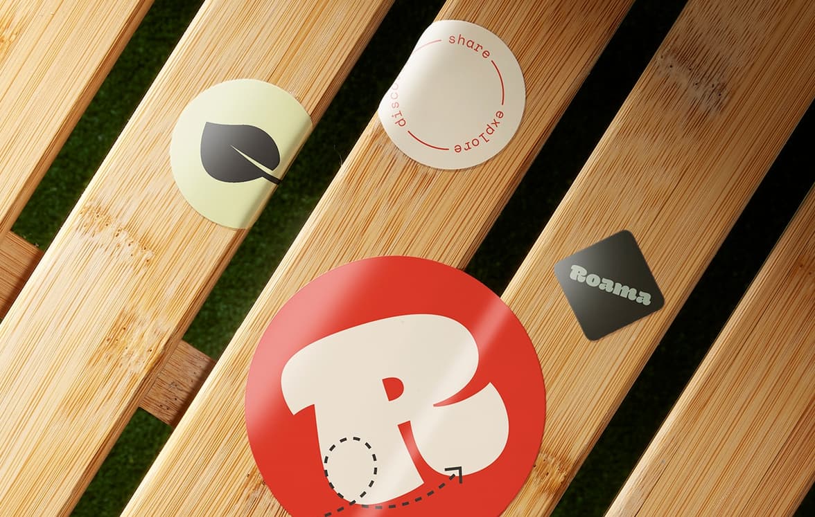 Customized matte paper sitckers, varying in size and shape on planks of wood.