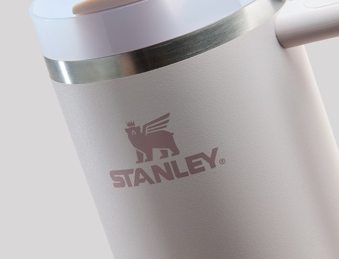 A close up image of a cream bottle with pink Stanley branding.